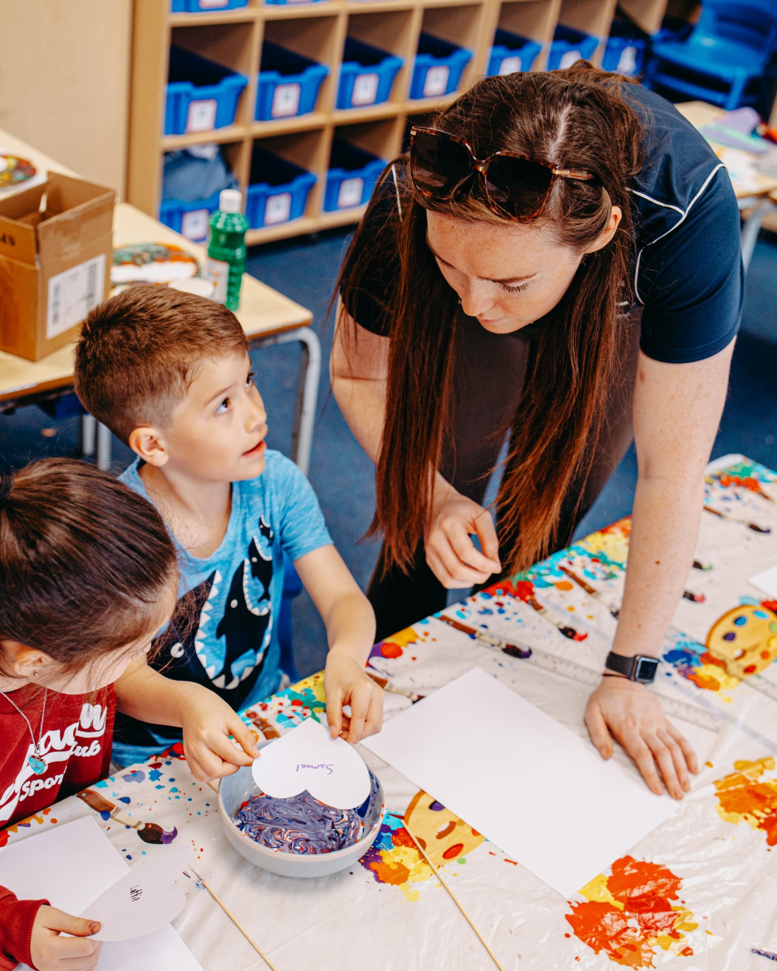 Foundation team member helping a child during an arts and crafts activity