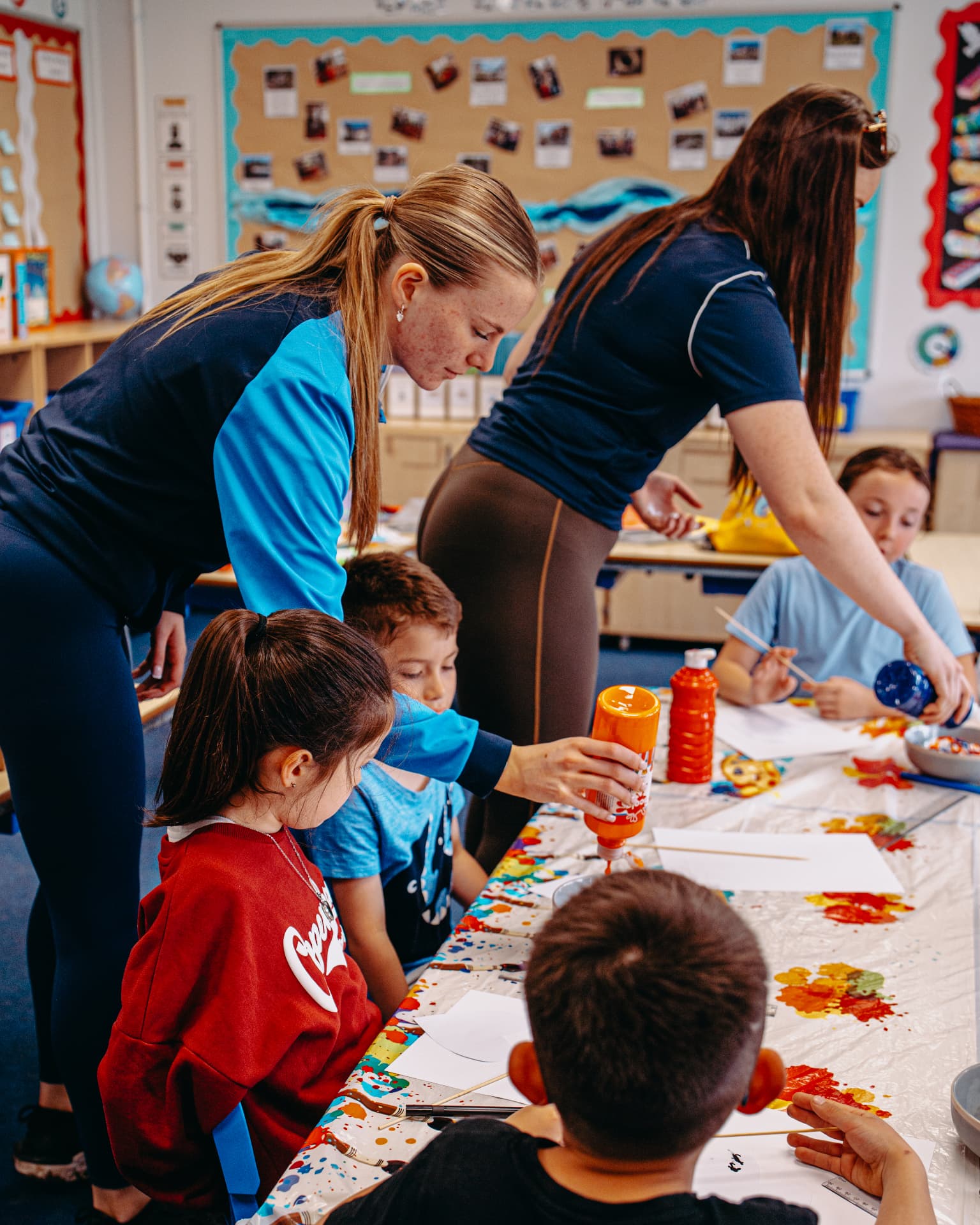 Foundation team supporting children with a colourful creative activity